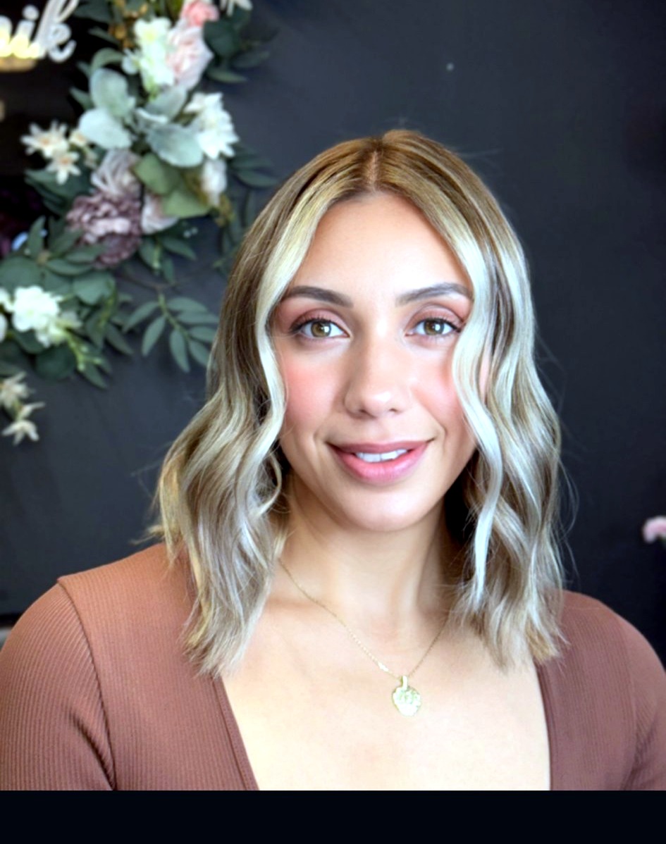 Josie smiling in front of a pink floral backdrop